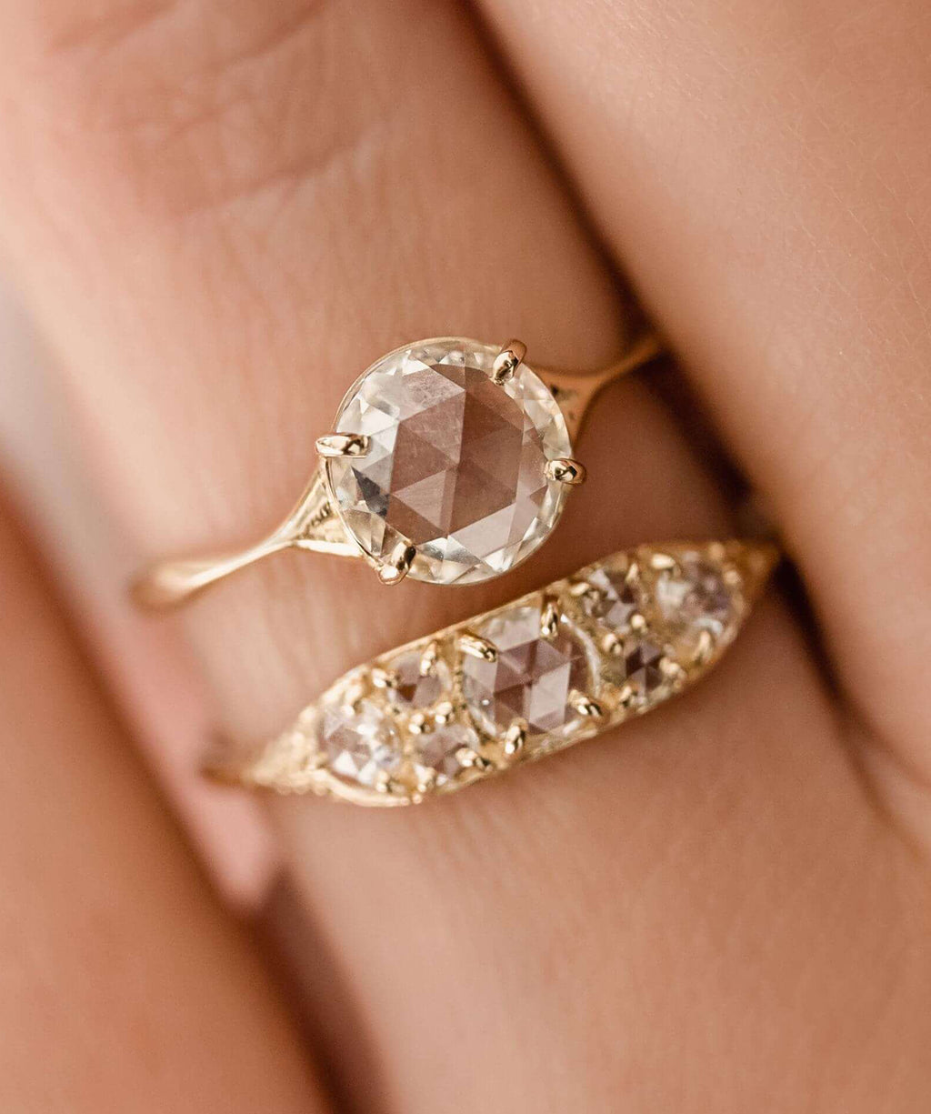 Photo showcases a model wearing the Corset Rose Cut Ring paired with the Overture Band on her hand.