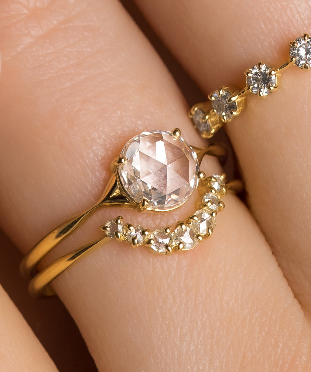 Photo showcases a model wearing the Corset Rose Cut Ring paired with the Plenilune Band on her hand.