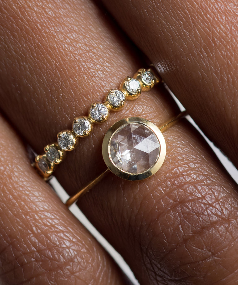 Photo showcases a model wearing the Edifice Bezel Set Rose Cut Ring paired with the Many Moons Band on her hand.