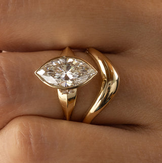 The Melanie Casey Bezel Set Marquise Cut Elixir Ring being worn by a model along with the Amplify Band.