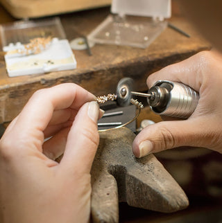 Photo of Melanie Casey working at her bench in 2015.