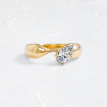 The Melanie Casey Dialogue Band in 14k Yellow Gold shown from a front view sitting on a textured white background.
