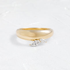 The Melanie Casey Foreshadow Band in 14k Yellow Gold shown from a front view sitting on a textured white background.