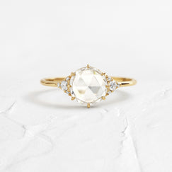 Ladys Slipper Rose Cut Engagement Ring in Yellow Gold by Melanie Casey shown on a textured white background