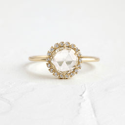 Luminary Rose Cut Engagement Ring in Yellow Gold by Melanie Casey shown on a textured white background