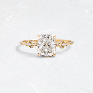 The Melanie Casey Myriad Ring in 14k Yellow Gold sitting on a textured white background.