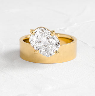 The Melanie Casey Perplex Ring in 14k Yellow Gold sitting on a textured white background.