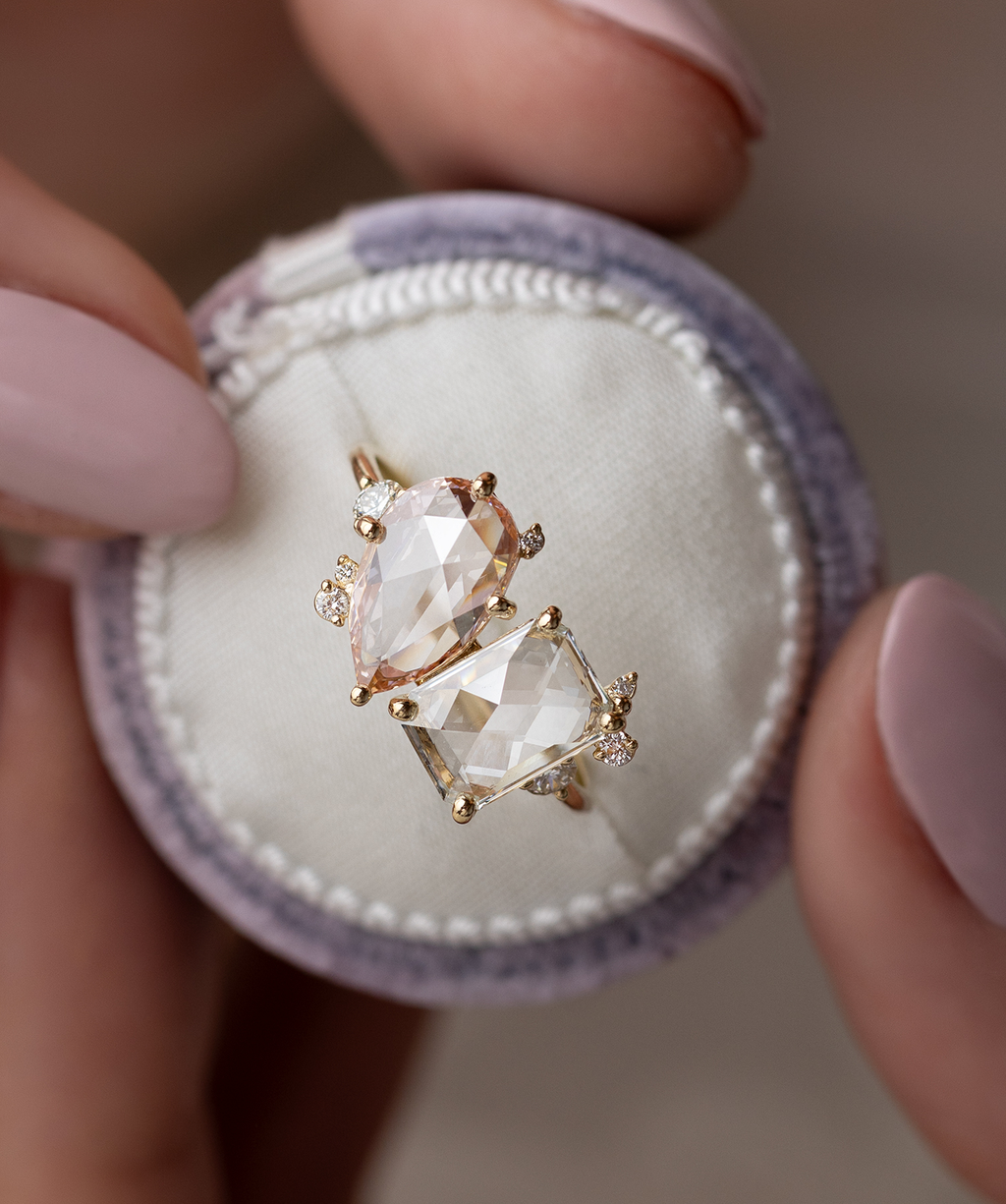 Photo features the one of a kind Melanie Casey Rose Cut Clarity Ring being held up by a model in a round ring box.