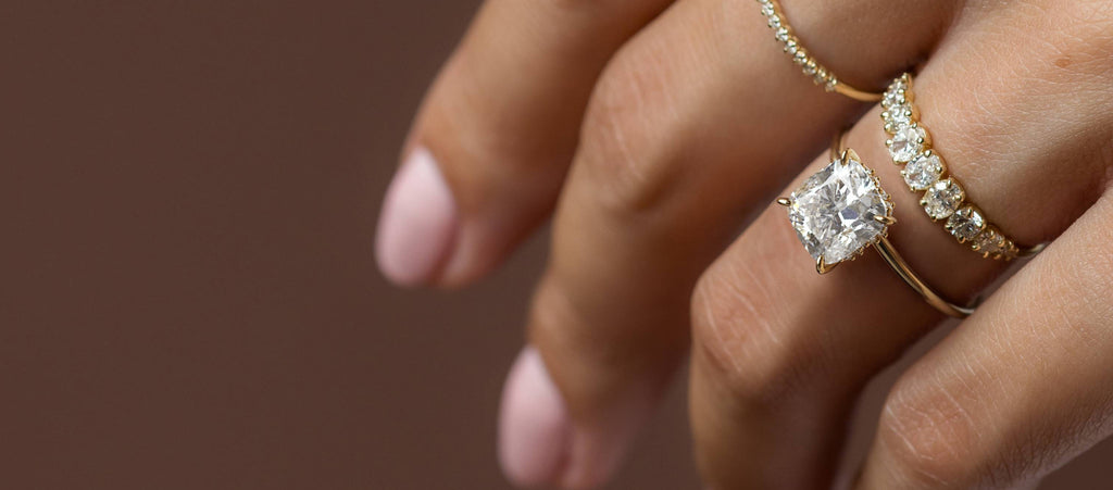 Photo showcases a model wearing the Melanie Casey Touchpoints Ring with an elongated Cushion Cut center stone.