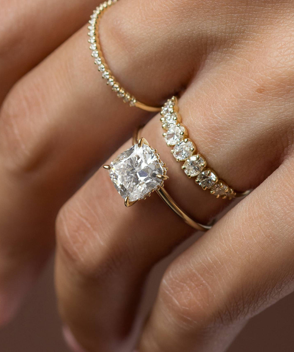 Photo showcases a model wearing the Melanie Casey Touchpoints Ring with an elongated Cushion Cut center stone.