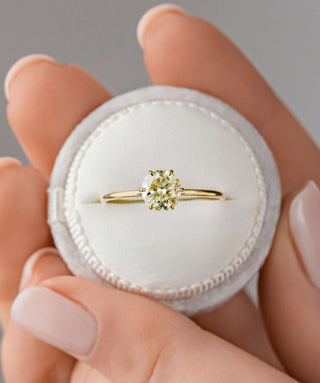 Photo features a model wearing the Melanie Casey Touchpoints Ring with a yellow diamond center stone.