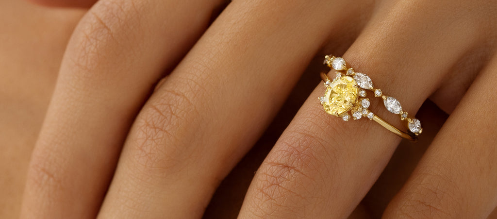 Photo showcases a model wearing the Stargaze Ring with a yellow diamond center stone.