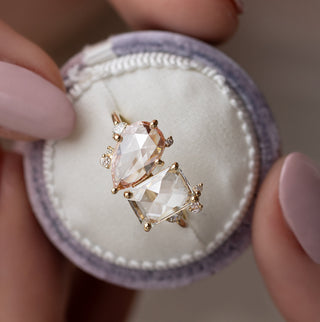 Photo features the one of a kind Melanie Casey Rose Cut Clarity Ring being held up by a model in a round ring box.