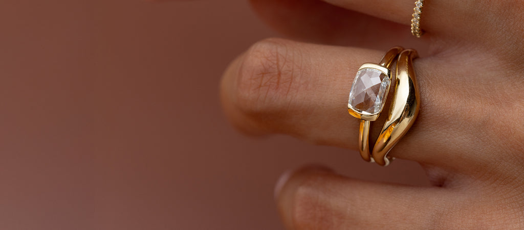 Model wearing the Stanza Ring, 0.94ct. Lab-Grown Cushion Rose Cut in front of a brown background.