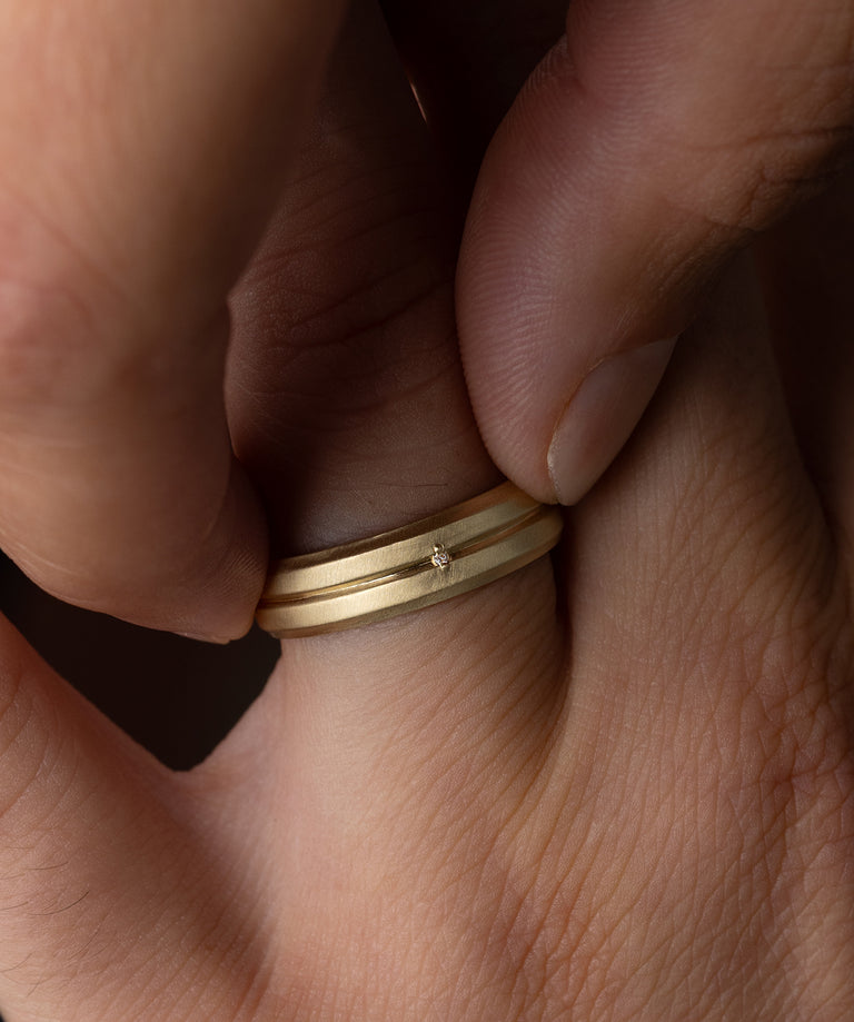 Photo showcases a model wearing a yellow gold Procession Band on his finger.
