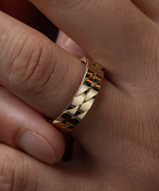 Photo showcases a model wearing the Melanie Casey men's Two Twines Band on his hand and holding it between two fingers.