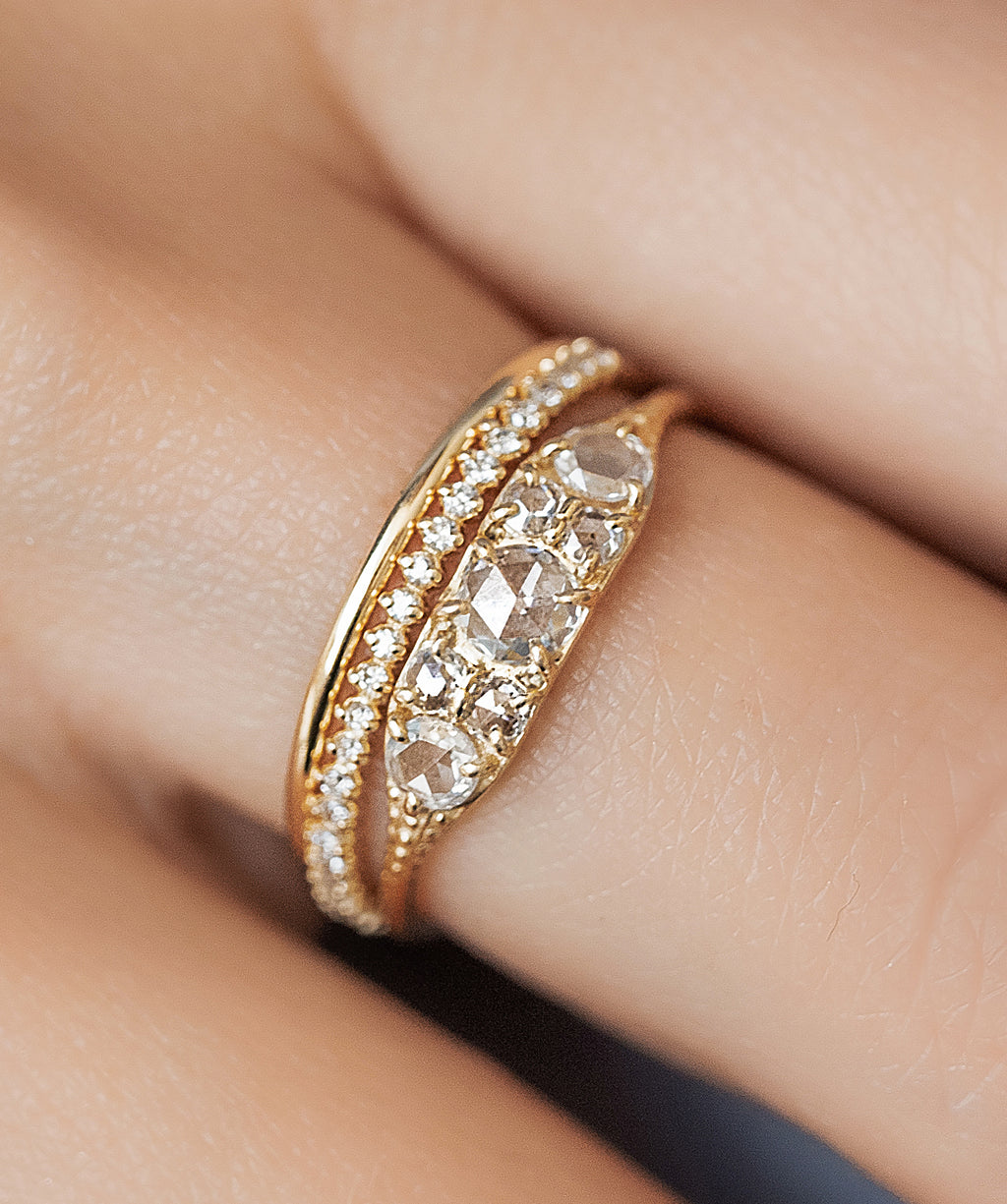 Photo showcases a model wearing the Overture Rose Cut Ring paired with the Petite Many Moons Band and the Pairing Band on her hand.