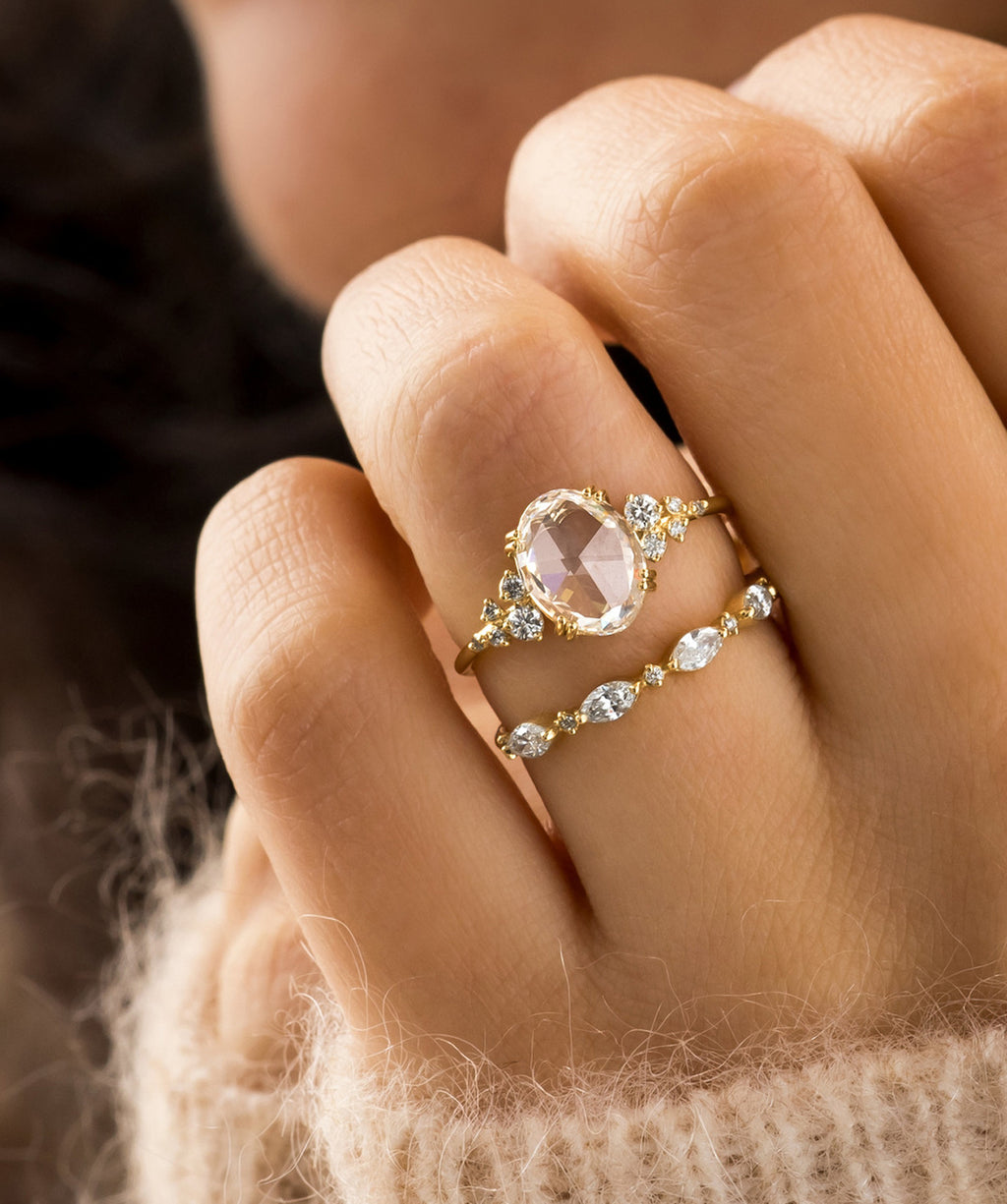Photo showcases a model wearing the Snowdrift Rose Cut Ring paired on top of the Interwoven Band on her hand.