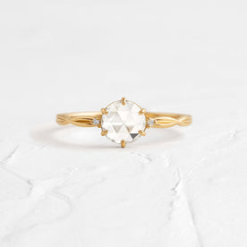 Twine Ring, Rose Cut Engagement Ring in Yellow Gold by Melanie Casey shown on a textured white background