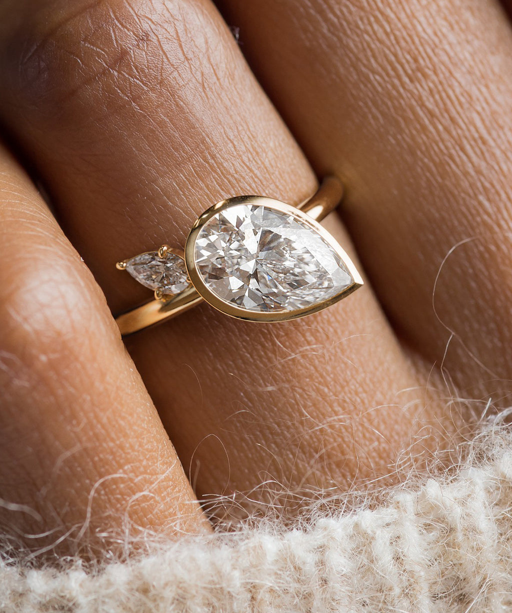 Photo features the Upcast Engagement Ring in Pear Cut on a model's hand.