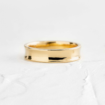 Photo shows a Melanie Casey Men's Concave Band sitting on a textured white background.