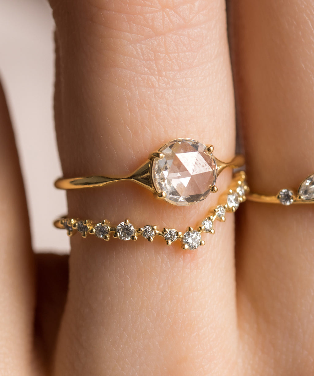 Photo showcases a model wearing the Corset Rose Cut Ring paired with the Curved Tinsel Band on her hand.