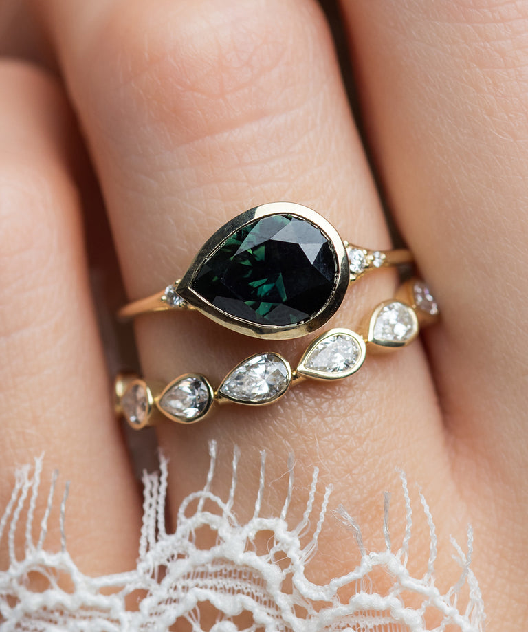 Photo features a model wearing a Melanie Casey Evenfall Ring with a Bluish Green Australian Sapphire, 2.52ct in Yellow Gold.