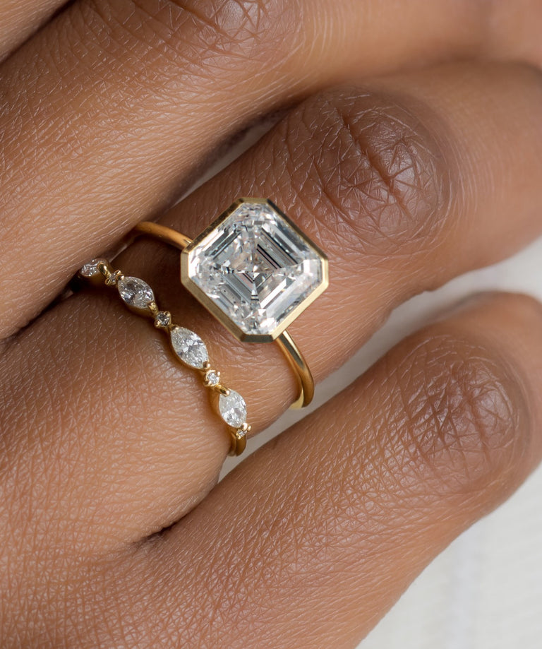 A Melanie Casey model wearing Formation Ring, Asscher Cut paired with an Interwoven Band.