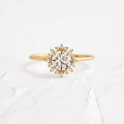Photo features the Harbor Ring, 0.7ct. Round Cut Natural Champagne Diamond on a textured white background.