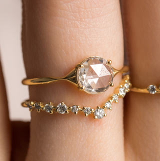 Photo features a model wearing the Corset Ring in Rose Cut and the Curved Tinsel Band.