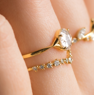 Photo features a model wearing a low profile Rose Cut Corset Engagement Ring in Yellow Gold.