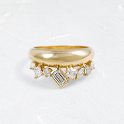 The Melanie Casey Cadance Band in 14k Yellow Gold shown from a front view sitting on a textured white background.