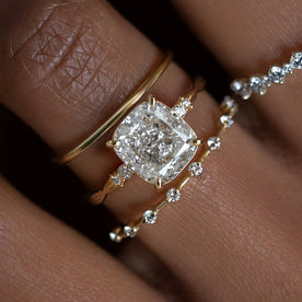 Photo showcases a model wearing the Melanie Casey Trestle Ring with an elongated Cushion Cut center stone.