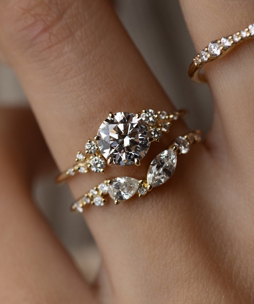 Photo showcases a model wearing the Round Cut Snowdrift Ring in Yellow Gold.