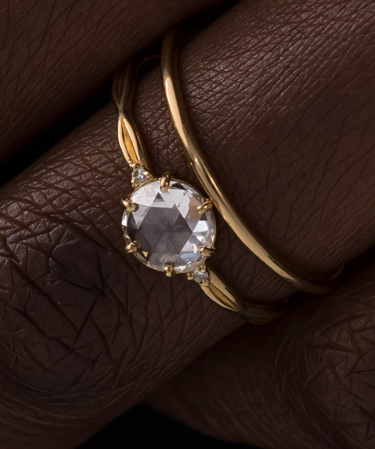 Photo features a model wearing the Rose Cut Twine Engagement Ring in Yellow Gold paired with the Pairing Band.