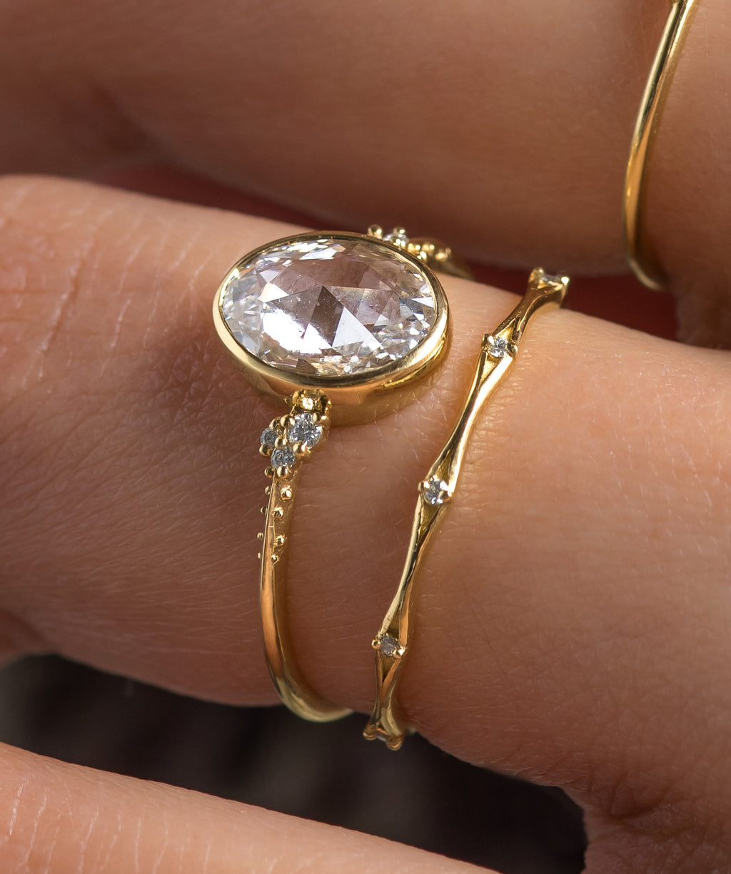 Photo features a model wearing a Pensive Engagement Ring in Oval Rose Cut