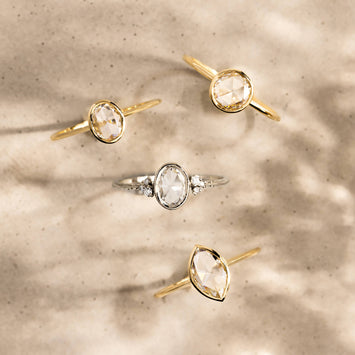 Photo features a bird's eye view of 4 bezel rose cut engagement rings.