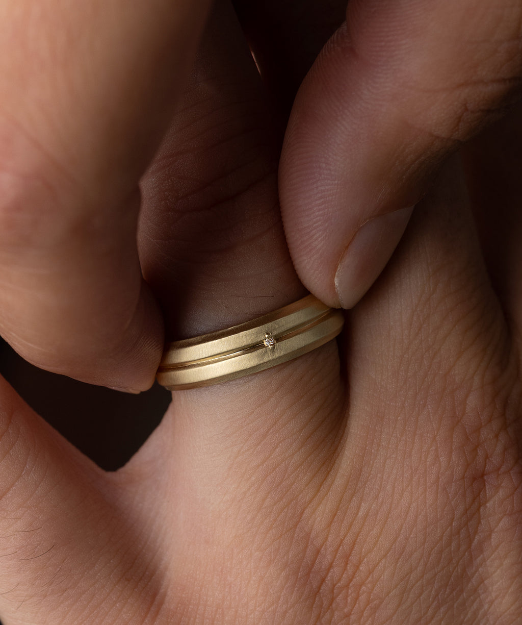 Photo showcases a model wearing a yellow gold Procession Band on his finger.