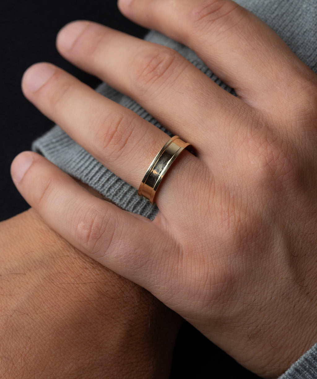 Photo showcases a model wearing the Melanie Casey Men's Square Band on his hand, which is resting on his other wrist.