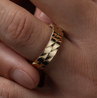 Photo showcases a model wearing the Melanie Casey men's Two Twines Band on his hand and holding it between two fingers.