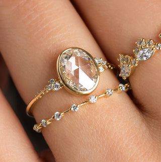 The Melanie Casey Bezel Set Pensive Ring in Oval Cut being worn by a model.