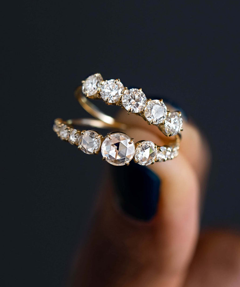 Photo showcases a model holding up the Rose Cut Diamond Waterway Ring and the Prelude Band.