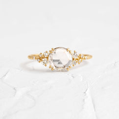 Snowdrift Ring, Rose Cut Engagement Ring in Yellow Gold by Melanie Casey shown on a textured white background