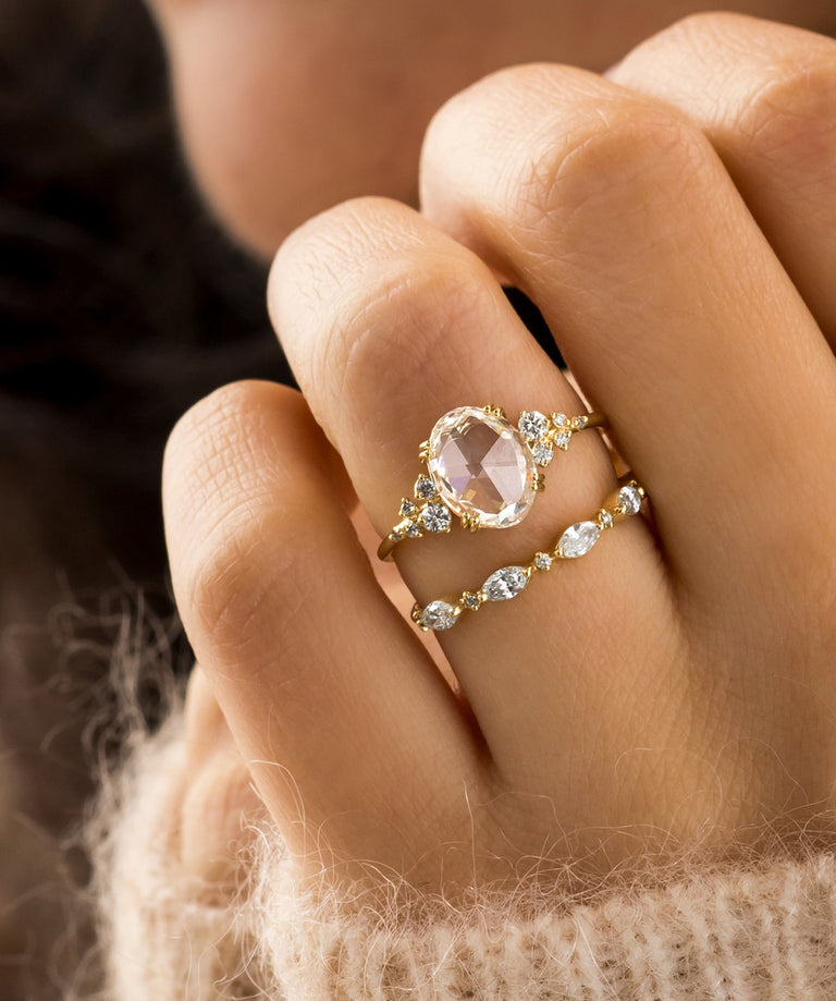 Photo showcases a model wearing the Snowdrift Rose Cut Ring paired on top of the Interwoven Band on her hand.