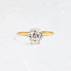 Photo showcases the Touchpoints Ring, with a 1.8ct. Natural Diamond on a textured white background.