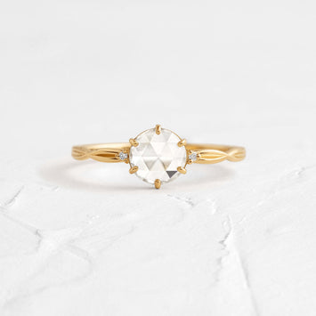Twine Ring, Rose Cut Engagement Ring in Yellow Gold by Melanie Casey shown on a textured white background